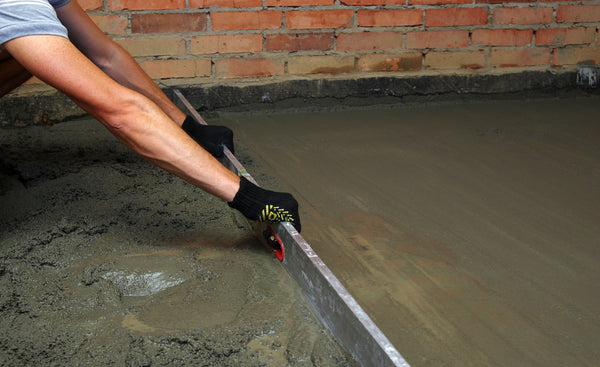 man using a concrete screed